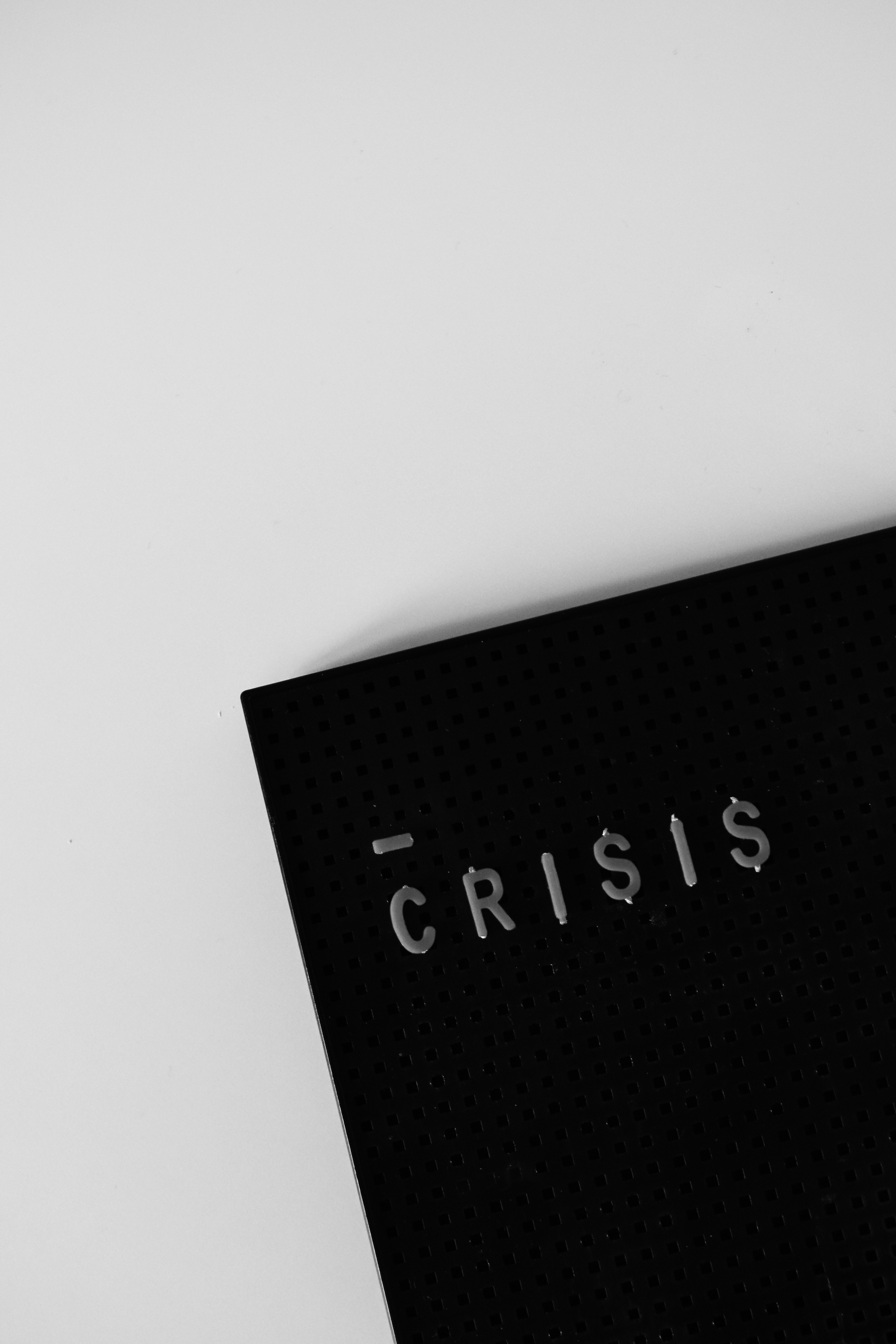 Mörk panel med upphöjda bokstäver som stavar CRISIS, symboliserar den realitet svenska organisationer möter i incidentprocesser efter NIS2.